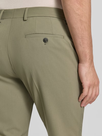 Männermodel trägt Slim Fit Anzughose mit Viskose-Anteil Modell 'LIAM' von SELECTED HOMME in melangelook, detailopname achteraanzicht. Context: heren pantalon, model 'LIAM', melangelook, slim fit pasvorm, detail: riemlussen, persplooien, knoop- en ritssluiting, Franse steekzakken, popeline materiaalverwerking, materiaalmix met viscose.