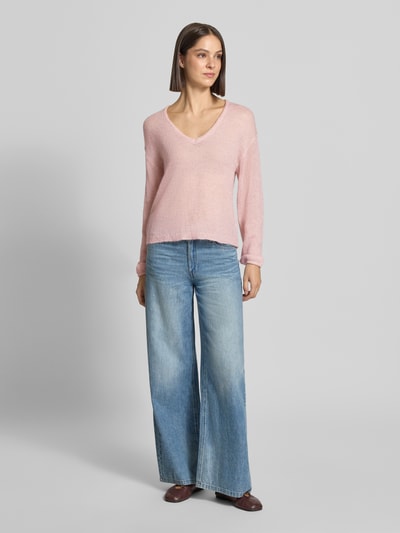Vrouwenmodel draagt relaxed fit dames pullover van FREE/QUENT, Model 'Dido', mix van katoen en alpacawol, V-hals, semi-transparante look, ruglengte maat S 56 cm, mouwlengte maat S 55 cm, lichtroze kleur, zachte textuur, ganse lichaamsaanzicht van voren.