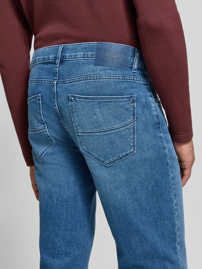 Männermodel trägt blaue Straight Fit Jeans aus Baumwoll-Mix Modell 'Cadiz' von Brax, sichtbare Nähte, Herren Straight Fit Jeans, Ganzkörperansicht Rückansicht.