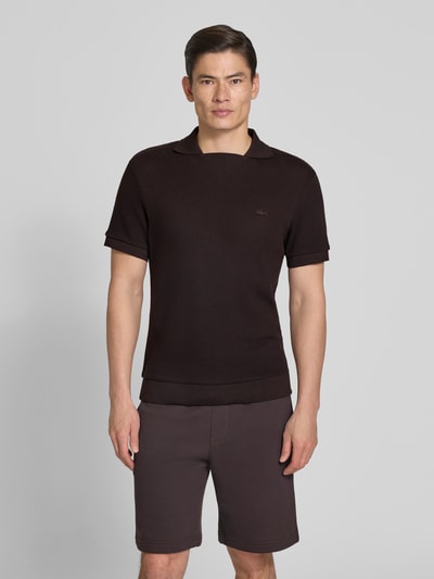 Männermodel trägt Regular Fit Poloshirt aus reiner Baumwolle von Lacoste, Optik: Unifarben, Struktur, Ganzkörperansicht von vorne.