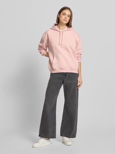 Vrouwenmodel draagt Hoodie met Kapuze van Levi's®, lichtroze, katoen-elastaan, losse pasvorm, kangoeroezak, voorkant, geheel lichaam.