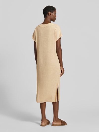 Frauenmodel trägt Strickkleid mit V-Ausschnitt Modell 'Delia' von Soyaconcept im Viskose-Mix mit Stretch-Anteil, Gerader-Schnitt, Midikleid, Rückenlänge Größe S 112 cm, Brustweite 54 cm, Ärmellänge 24 cm, sandfarben, feine Stricktextur, Ganzkörperansicht Rückansicht.