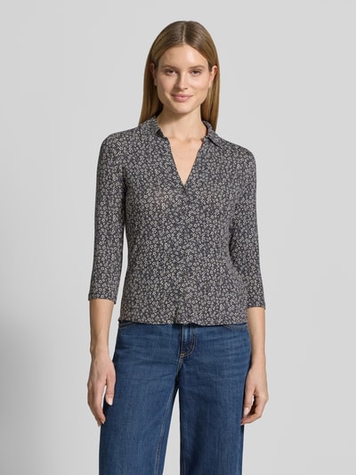 Frauenmodel trägt Shaped Fit Blusenshirt aus Viskose-Mix von Marc O'Polo, efekt: wzór na całej powierzchni, krój shaped fit, kołnierzyk koszulowy, kwiatowy wzór, pas na plecach, dekolt w serek, listwa guzikowa, rękaw o dł. 3/4, wykończenie materiału: mieszanka wiskozy; Ganzkörperansicht von vorne.