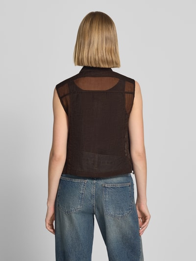 Frauenmodel trägt Weste in semitransparentem Design von monari, Schwarz, strukturierte Textur, taillierte Passform, Ganzkörperansicht Rückansicht.