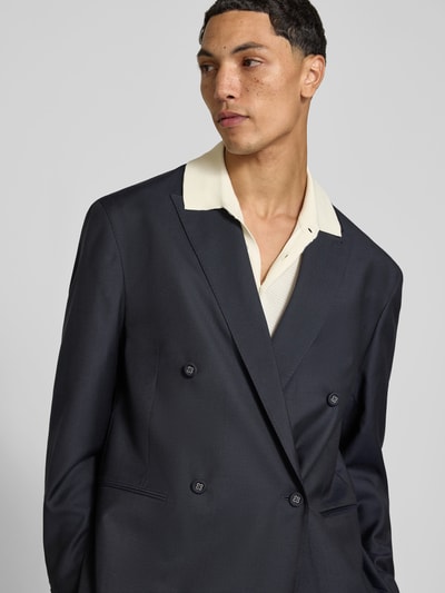 Männermodel trägt Regular Fit Sakko aus Woll-Mix von Officine Générale in Dunkelblau, Doppelreiher, Nahaufnahme Oberkörper, Woll-Kaschmir-Mix mit Seide-Anteil, Reverskragen, Paspeltaschen.