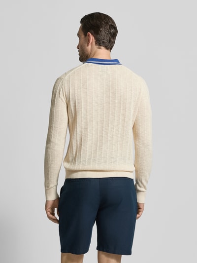 Männermodel trägt Strickpullover aus Leinen-Mix mit Polokragen von Gant, kolor kremowy, krój slim fit, detal niebieskiego kołnierza, długość tyłu 68 cm, rękaw 70 cm, widok całej sylwetki z tyłu.