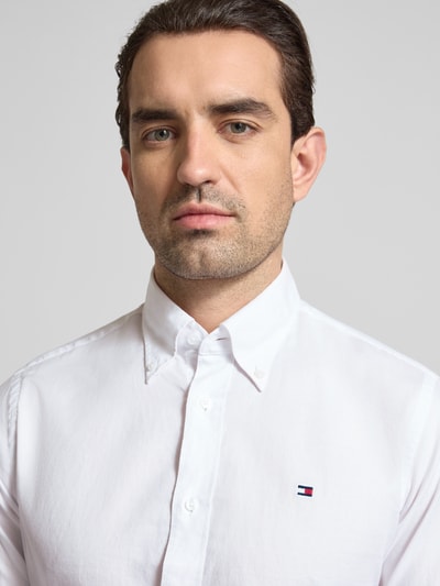 Männermodel trägt Regular Fit Freizeithemd aus reiner Baumwolle von Tommy Hilfiger, Optik: Unifarben, Nahaufnahme Oberkörper.