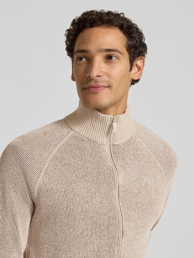 Männermodel trägt Regular Fit Strickjacke mit Stehkragen von Jake*s Studio Men in Beige mit grober Strickstruktur, Nahaufnahme Oberkörper.