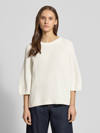 Modelka nosi Oversized Strickpullover aus reiner Baumwolle Modell 'MARGE' od JJXX, biała dzianina, okrągły dekolt, 3/4 rękawy, prążkowane wykończenia, Ganzkörperansicht von vorne.