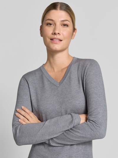 Frauenmodel trägt Pullover aus Viskose-Mix mit V-Ausschnitt von Christian Berg Woman, grauer Ton, gerippte Abschlüsse, Nahaufnahme Oberkörper.