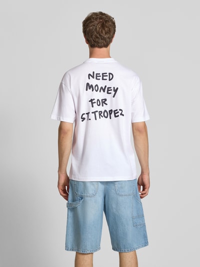 Männermodel trägt Herren T-Shirt von Only & Sons Modell 'MONEY' in Optik: Unifarben, Loose-Fit, Statement-Print, reine Baumwolle, Ganzkörperansicht Rückansicht.