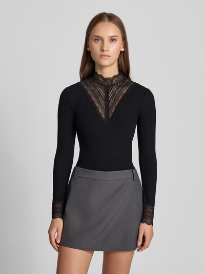 Frauenmodel trägt schwarzes Slim Fit Langarmshirt aus Viskose-Mix Modell 'TILDE' von ONLY, Spitzen- und Strukturdetails, Ganzkörperansicht von vorne, Damen Langarmshirt von ONLY.