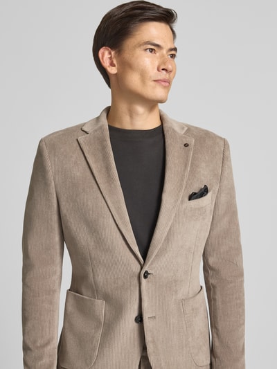 Männermodel trägt Slim Fit Sakko aus Baumwoll-Mix in Cord-Optik Modell 'Nick' von Zuitable, beige, strukturierte Oberfläche, Nahaufnahme Oberkörper.