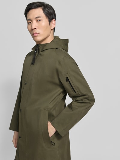 Männermodel trägt Regular Fit Jacke mit Kapuze Modell 'Spirit' von G-LAB aus olivgrünem Baumwoll-Mix mit Reißverschluss, Eingrifftaschen, Armtasche und Logo-Detail, Ganzkörperansicht von vorne. Rückenlänge 86 cm, Schulterbreite 49 cm, Brustweite 56 cm, Ärmellänge 62 cm.
