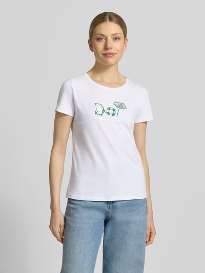 Frauenmodel trägt T-Shirt mit Motiv-Print und Rundhalsausschnitt von More & More, Damen T-Shirt im Regular-Fit aus Baumwoll-Elasthan-Mix, Rückenlänge 58 cm bei Größe 36, weiße Farbe mit grünem Motiv, glatte Textur, Ganzkörperansicht von vorne.
