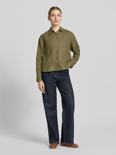 Frauenmodel trägt Regular Fit Hemdbluse aus reinen Leinen von Christian Berg Woman Selection, Olivgrün, strukturierte Textur, Ganzkörperansicht von vorne. Damen Hemdbluse, Hemdblusenkragen, durchgängige Knopfleiste, langärmelig, Rückenlänge 64 cm, Ärmellänge 56 cm, Größe 36.