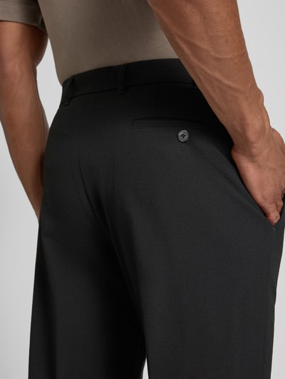Mężczyzna nosi Slim Fit Hose mit Tunnelzug od DIGEL, kolor czarny, materiał z domieszką wełny, krój slim fit, szerokość w rozmiarze 50: 45 cm, długość nogawki: 82 cm, detal tylnej kieszeni, zbliżenie tylnej części.