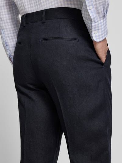 Männermodel trägt Anzughose mit Gesäßtaschen Modell 'Tense' von Tiger Of Sweden aus dunkelblauem Leinen, Regular Fit, Detailaufnahme Rücken.