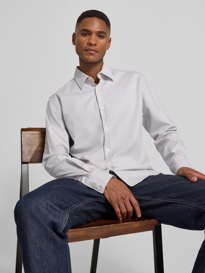Männermodel trägt Regular Fit Freizeithemd aus Baumwoll-Mix Modell 'RELEGANT_6_M' von BOSS Orange, Nahaufnahme Oberkörper. Optik: Unifarben, durchgehend Knopfleiste, Muster: Gepunktet, Kentkragen, Langarm mit 2-Knopf-Manschette, Label Patch, Rückenpasse, abgerundeter Rumpfabschluss, Materialverarbeitung: Webware.
