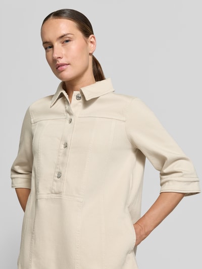 Frauenmodel trägt Knielanges Hemdblusenkleid mit Knopfleiste und 1/2-Arm von Marc Cain in Beige, Hemdblusenkragen, gerader Schnitt, Nahaufnahme Oberkörper. Rückenlänge 89 cm, Brustweite 52 cm, Ärmellänge 31 cm.
