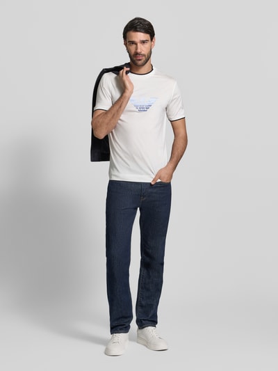 Männermodel trägt Regular Fit T-Shirt mit Logo-Stitching von Emporio Armani, Lyocell-Mix, weiß, Rundhalsausschnitt, Ganzkörperansicht von vorne.