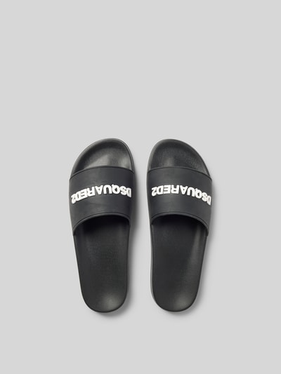 Produktfoto, Slides mit Label-Detail von Dsquared2 in Schwarz, abgerundete Form, offene Ferse, glatte Sohle, Absatzhöhe 3 cm bei Größe 45.