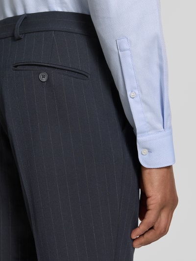 Männermodel trägt Slim Fit Anzughose mit Viskose-Anteil Modell 'PETER' von SELECTED HOMME, dunkle Farbe, feine Streifen, Nahaufnahme Hüfte.