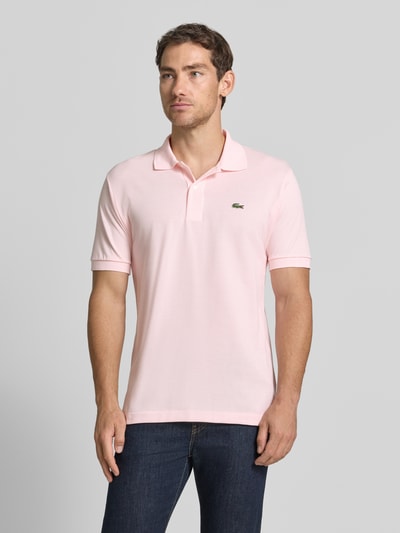 Männermodel trägt Regular Fit Poloshirt aus reiner Baumwolle von Lacoste in Hellrosa, glatte Struktur, Ganzkörperansicht von vorne, Herren Poloshirt von Lacoste