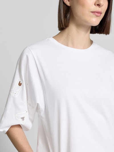 Frauenmodel trägt T-Shirt mit 3/4-Arm und Lochstickerei von Marc Cain, reine Baumwolle, Regular Fit, weiß, Nahaufnahme Oberkörper.