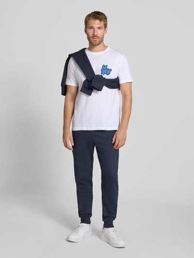 Männermodel trägt Slim Fit Sweatpants aus reiner Baumwolle von Paul Smith in Dunkelblau, glatte Struktur, Ganzkörperansicht von vorne. Herren Sweatpants, Elastikbund mit Tunnelzug, seitliche Eingrifftaschen, Gesäßtaschen, Innenbeinlänge 43 cm in Größe M.