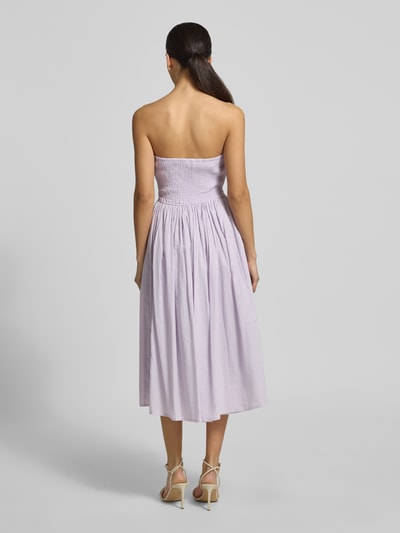 Vrouwenmodel draagt 'Cocktailkleid mit Spaghettiträgern' van LACE & BEADS in lichtpaars, katoen, a-lijn, midilengte, rugzijde opgenomen, ganzebody achteraanzicht.