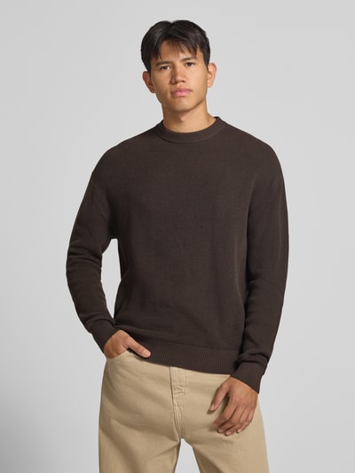 Männermodel trägt Regular Fit Strickpullover aus reiner Baumwolle von REVIEW, braun, strukturierte Oberfläche, Rundhalsausschnitt, Ganzkörperansicht von vorne.