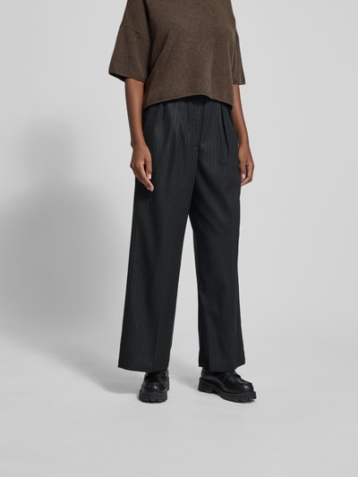 Frauenmodel trägt Stoffhose mit Bundfalten von black palms, Material-Mix mit Viskose-Anteil, lockerer Schnitt, Nahaufnahme Oberkörper