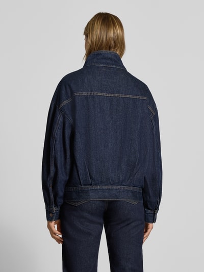 Frauenmodel trägt Modell 'T3 BLOUSON TRUCKER' von Levi's®, dunkelblauer Denim, lockere Passform, Kontrastnähte, Damen Jeansjacke, Ganzkörperansicht Rückansicht.