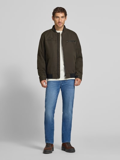 Männermodel trägt Blouson mit Stehkragen und Eingrifftaschen von camel active, Grün- und Brauntöne, Reißverschlüsse, Ganzkörperansicht von vorne, Regular Fit