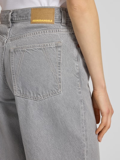 Frauenmodel trägt graue Wide Leg Jeans aus Lyocell-Baumwoll-Mix, 5-Pocket-Design, Label Patch von Armedangels, Nahaufnahme Rückansicht.