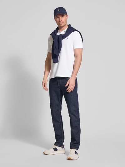 Männermodel trägt Slim Fit Poloshirt aus Baumwoll-Mix von Polo Ralph Lauren in Optik: Unifarben mit Logo-Detail, Ganzkörperansicht von vorne.