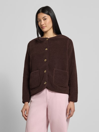 Frauenmodel trägt Regular Fit Teddyjacke mit ausgesetzten Taschen Modell 'SC-ONYX 2' von Soyaconcept in Dunkelbraun mit markanten Knöpfen und aufgesetzten Taschen, Kombination mit heller Hose, Damen Teddy- / Webpelzjacke von Soyaconcept, Ganzkörperansicht von vorne.