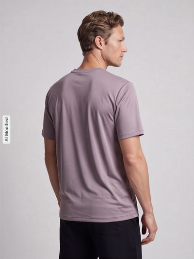 Männermodel trägt T-Shirt mit Logo-Print und Rundhalsausschnitt von NIKE TRAINING in Flieder, schwarze Shorts, glatter Stoff, Ganzkörperansicht Rückansicht, Rückenlänge bei Größe M 66 cm, KI-modifiziertes Bild.