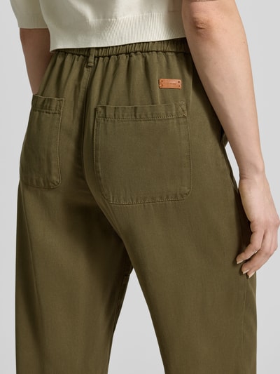 Frauenmodel trägt Straight Fit Stoffhose aus reinem Lyocell Modell 'Maison' von MOS MOSH in Olivgrün, elastischer Bund, Detailaufnahme Rückansicht.