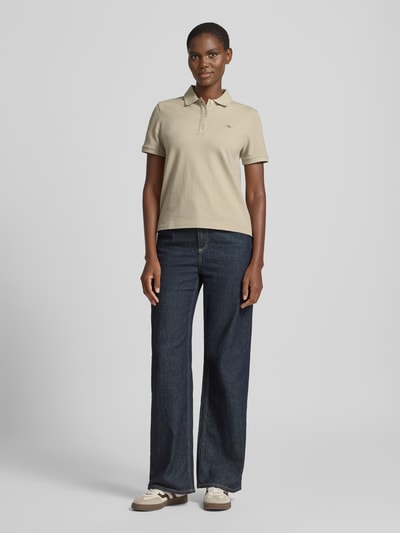 Frauenmodel trägt Poloshirt mit Logo-Stitching und Polokragen von Gant in Beige, Reine Baumwolle, Regular-Fit, Ganzkörperansicht von vorne.