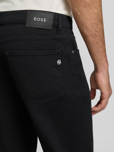 Männermodel trägt schwarze Straight Fit Jeans aus Baumwoll-Mix Modell 'Re.Maine' von BOSS, Nahaufnahme Rückansicht, Herren Straight Fit Jeans von BOSS.