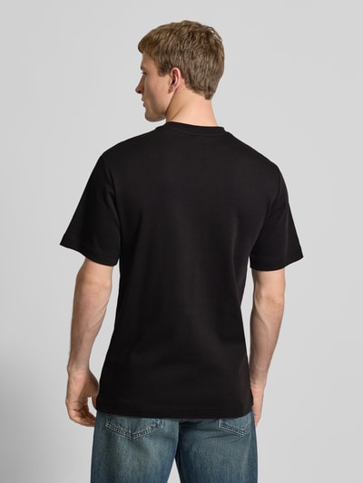 Męski model nosi Regular Fit T-Shirt mit Logo-Print Modell 'True' von G-Star Raw, czarny kolor, okrągły dekolt, długość tyłu w rozmiarze M: 66 cm, Ganzkörperansicht Rückansicht.