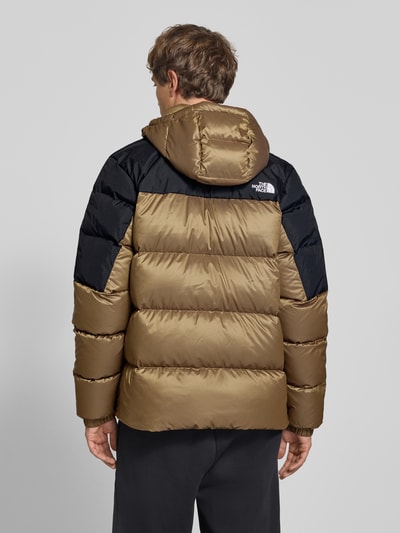 Männermodel trägt Regular Fit Jacke in Stepp-Optik Modell 'Diabolo' von The North Face, zweifarbig, mit Stehkragen und Logo-Stitching, Ganzkörperansicht Rückansicht.