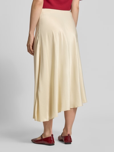 Modelka nosi spódnica midi z mieszanki wiskozy model 'Bethanie' od MSCH Copenhagen, kremowy kolor, asymetryczny krój, elastyczny pas, szerokość w rozmiarze S: 39 cm, całkowita długość w rozmiarze S: 72 cm, widok całej sylwetki z tyłu.