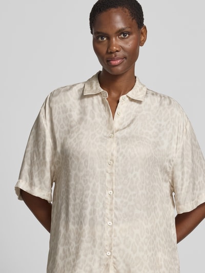 Frauenmodel trägt Relaxed Fit Hemdbluse mit Viskose-Anteil von Anine Bing, Cupro-Mix, Allover-Animal-Print, Halbärmel, crème-beigefarben, Nahaufnahme Oberkörper.