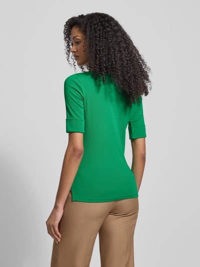 Frauenmodel trägt T-Shirt mit geripptem U-Boot-Ausschnitt Modell 'JUDY' von Lauren Ralph Lauren, Baumwoll-Elasthan-Mix, Slim Fit, Rückansicht, Rückenlänge 58 cm bei Größe S, in Grün und Beige. Ganzkörperansicht Rückansicht.