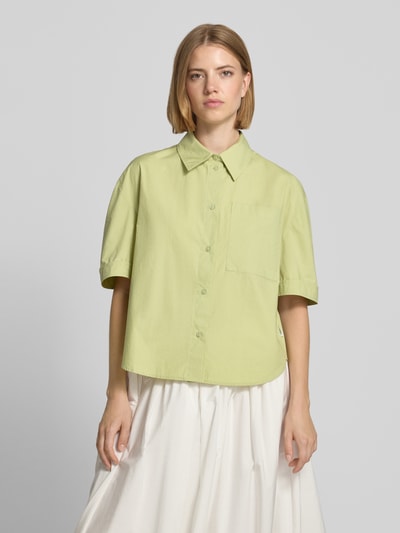 Frauenmodel trägt Regular Fit Kurzarmbluse aus reiner Baumwolle von s.Oliver RED LABEL in Hellgrün, lockere Passform, matte Optik, Ganzkörperansicht von vorne.