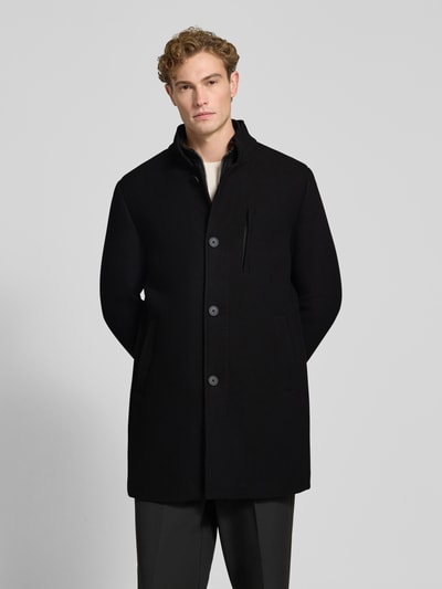 Männermodel trägt czarny Regular Fit płaszcz z stójką, zapięcie na guzik i zamek błyskawiczny, Brustasza, wpuszczane kieszenie, Regular Fit Mantel mit Knopf- und Reißverschluss von ROY ROBSON, długość tyłu 91 cm, szerokość ramion 47 cm, szerokość w rozmiarze klatki piersiowej 55 cm, długość rękawów 69 cm, Ganzkörperansicht von vorne