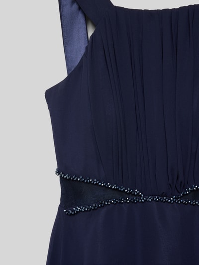 Mädchen trägt Maxikleid mit Nahtreißverschluss von G.O.L., taillierter Schnitt, blickdichtes Unterkleid, Raffungen, Nahaufnahme Oberkörper.